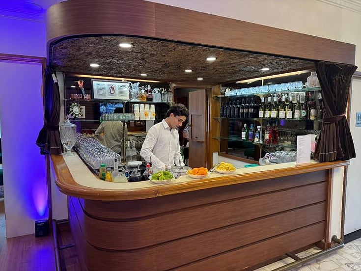 Electric Events bartender running a timber venue bar with garnishes and glassware set up
